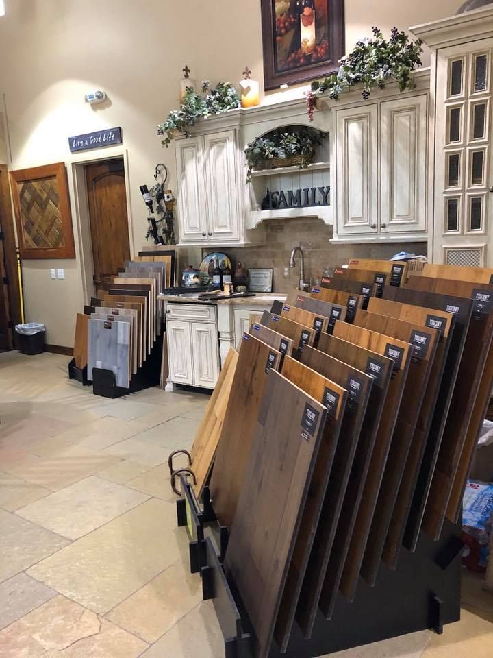 A display of wooden flooring in a store with a kitchen in the background.