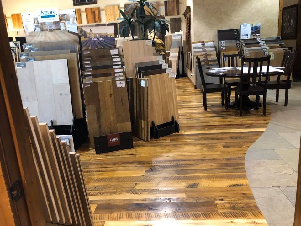 A showroom filled with lots of wooden floors and tables and chairs.