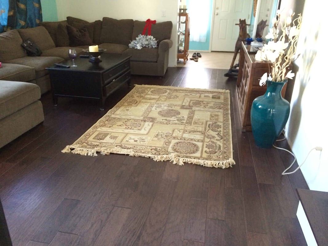 A living room with a couch , coffee table , rug and vases.