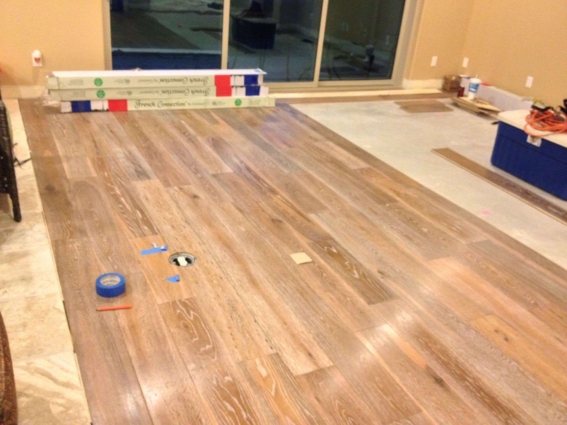 A wooden floor is being installed in a living room