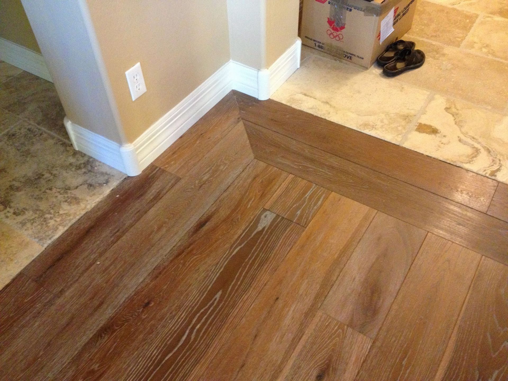 A wooden floor in a room with a box on the floor.