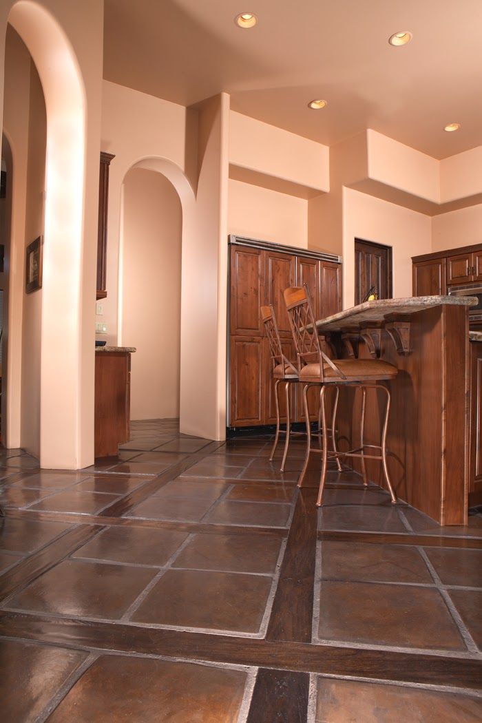 A kitchen with a tiled floor and wooden cabinets