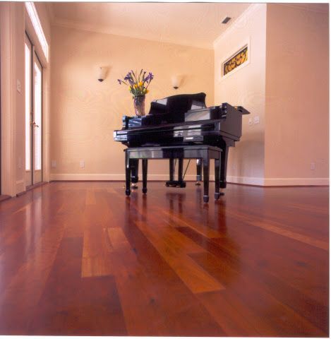 A piano is sitting on a wooden floor in a room