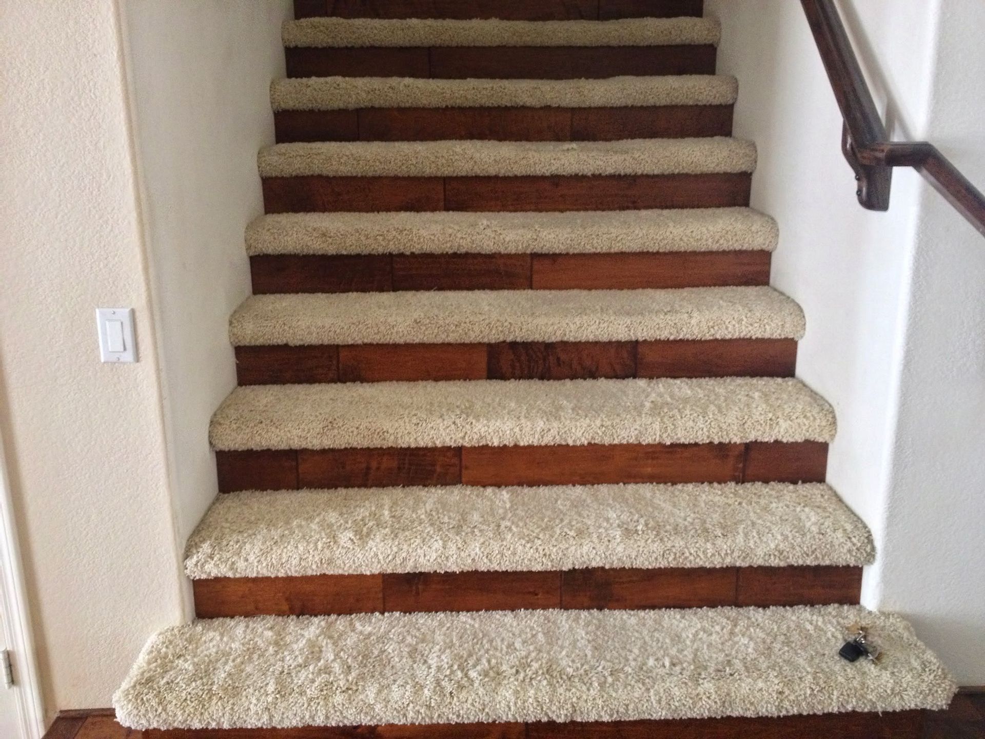 A set of stairs with carpeted steps and wooden steps