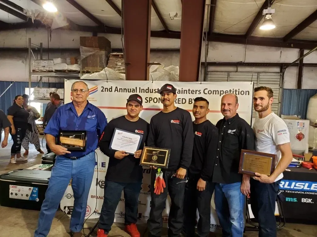 A group of men are standing in a room holding plaques.