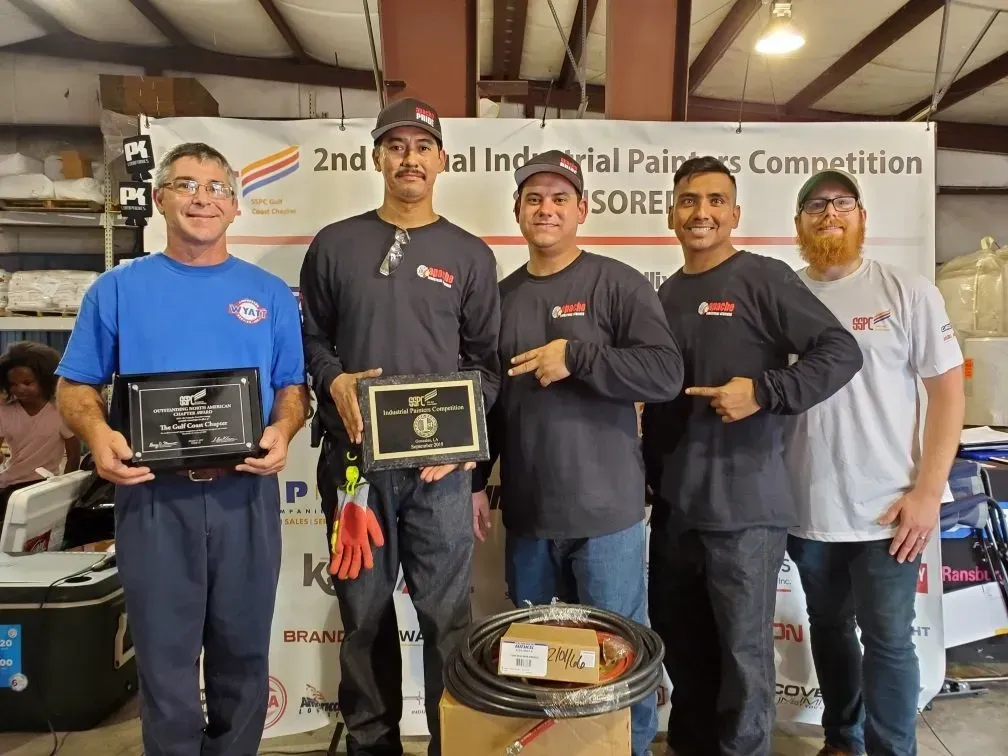 A group of men are posing for a picture in front of a sign.