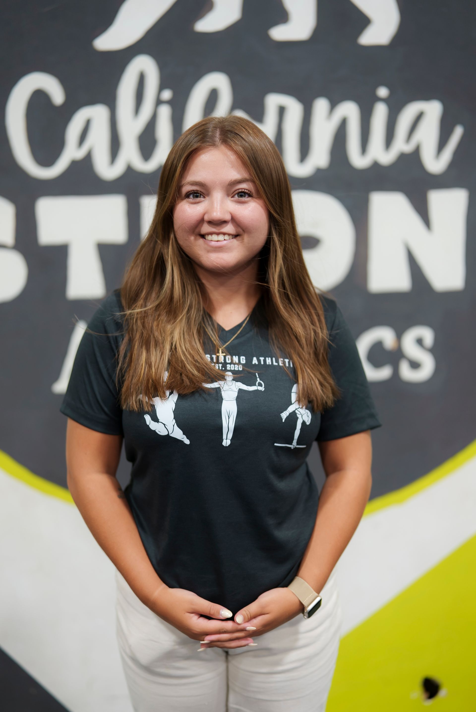 A man with a beard is smiling and wearing a maroon shirt