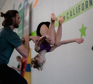 A group of children are standing in a circle with their heads together and smiling.