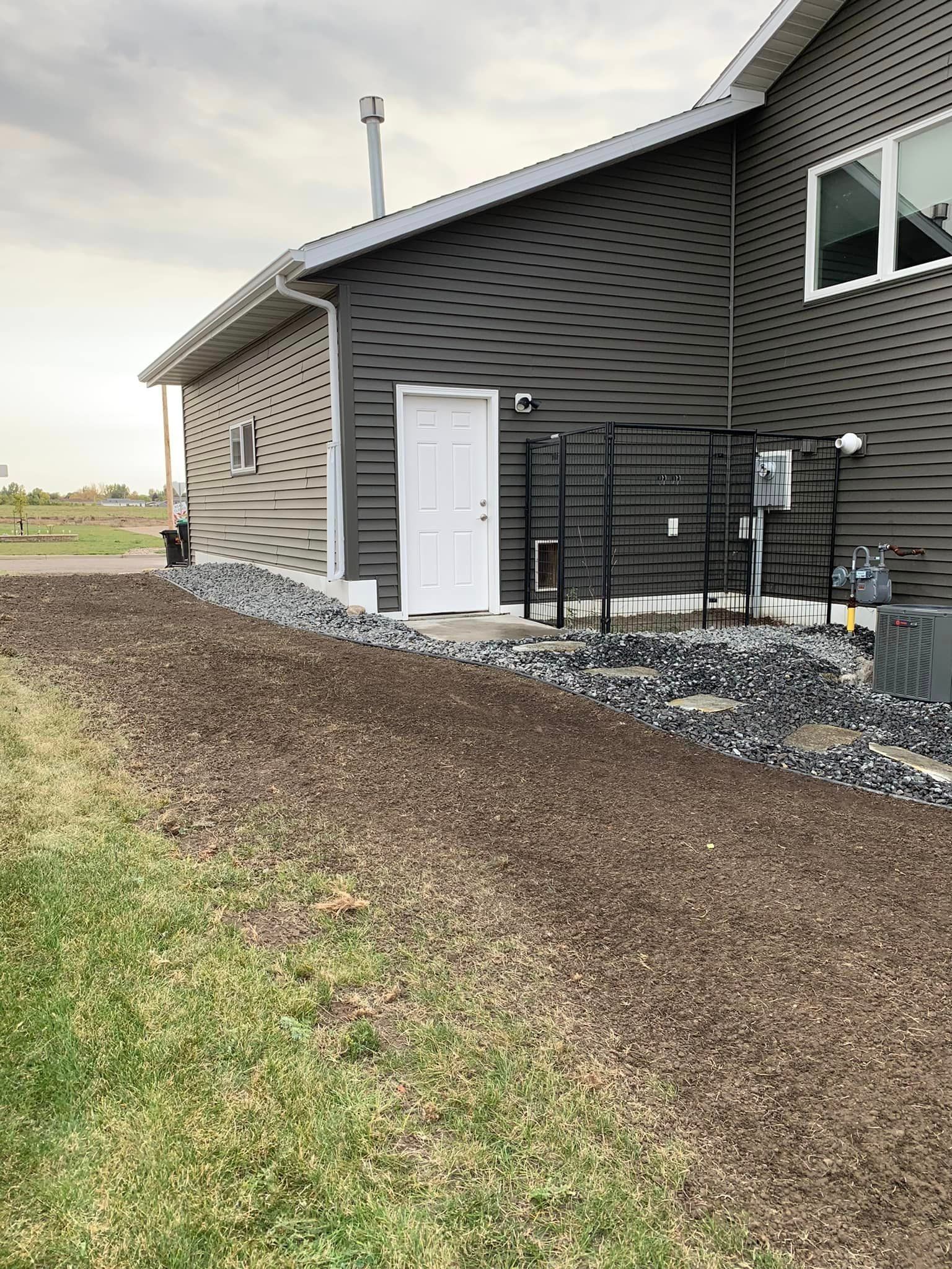 A house with a white door and a lot of rocks in front of it.