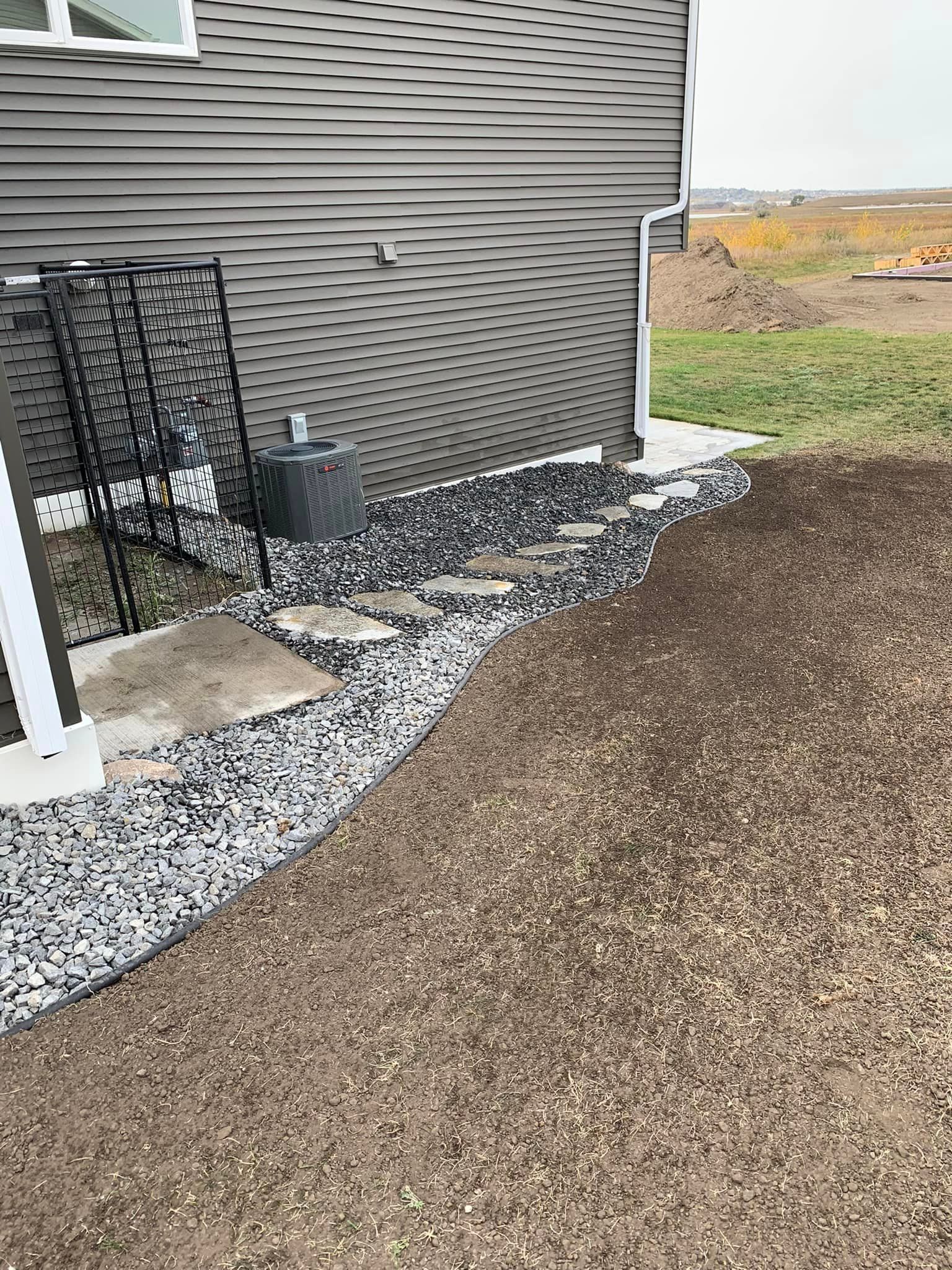 There is a walkway leading to the backyard of a house.