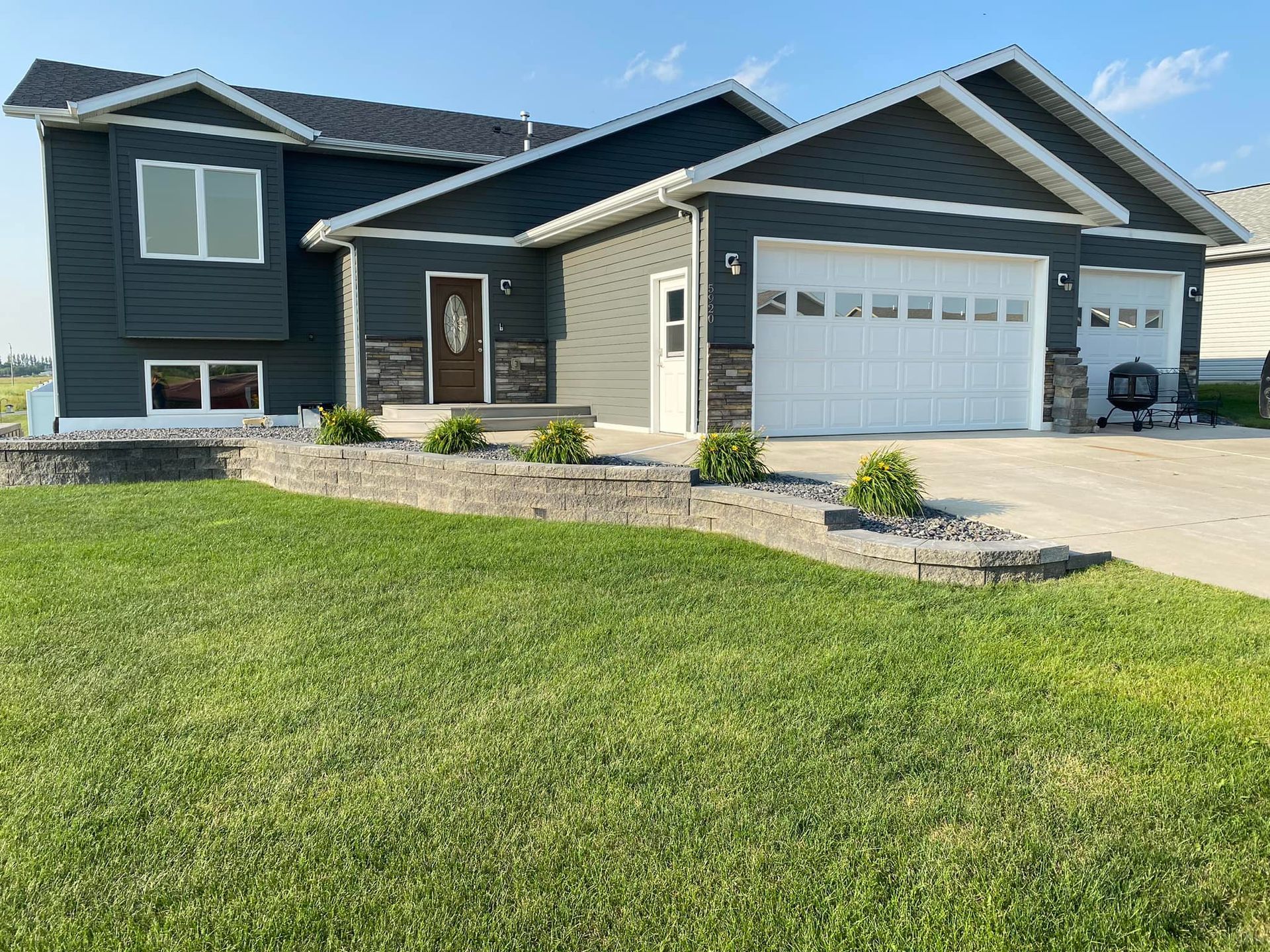 A large house with a large garage and a large lawn in front of it.