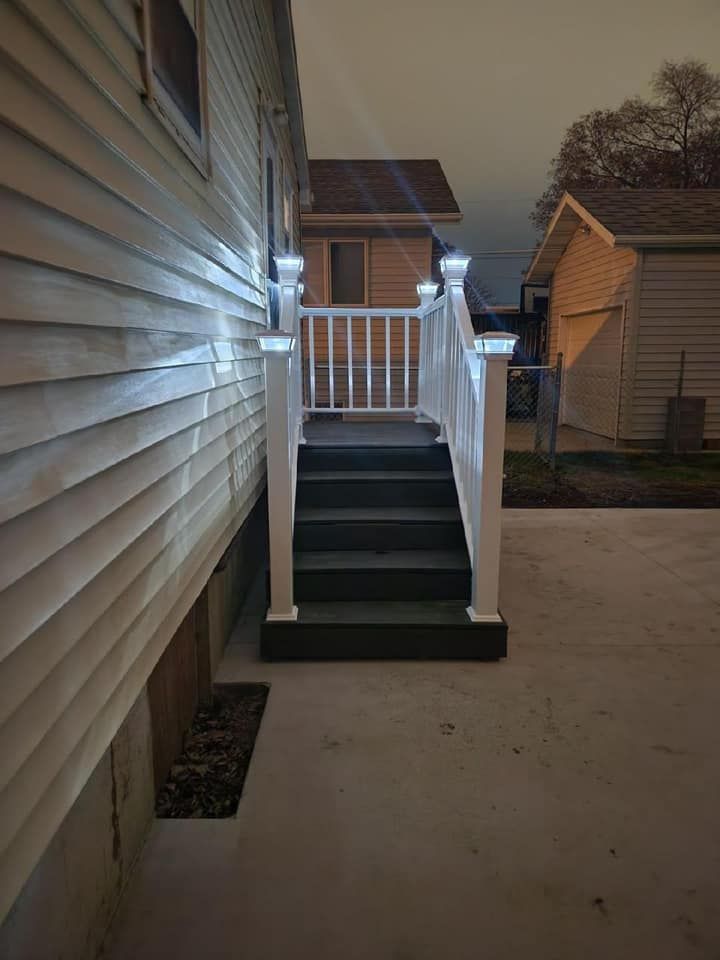 A house with stairs leading up to it and a white railing.