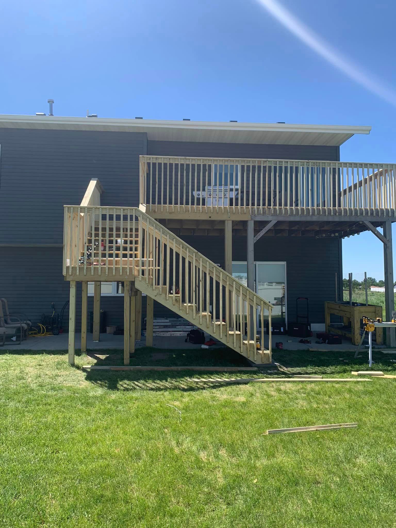 A house with a wooden deck and stairs in front of it.