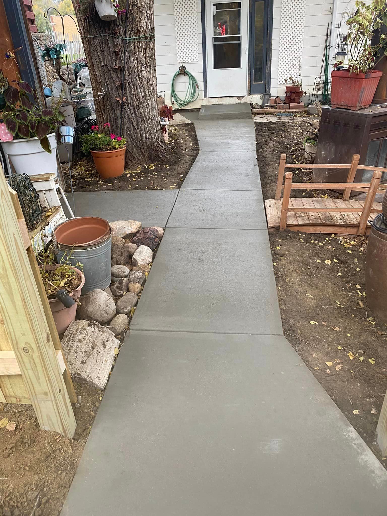 A concrete walkway leading to the front door of a house.