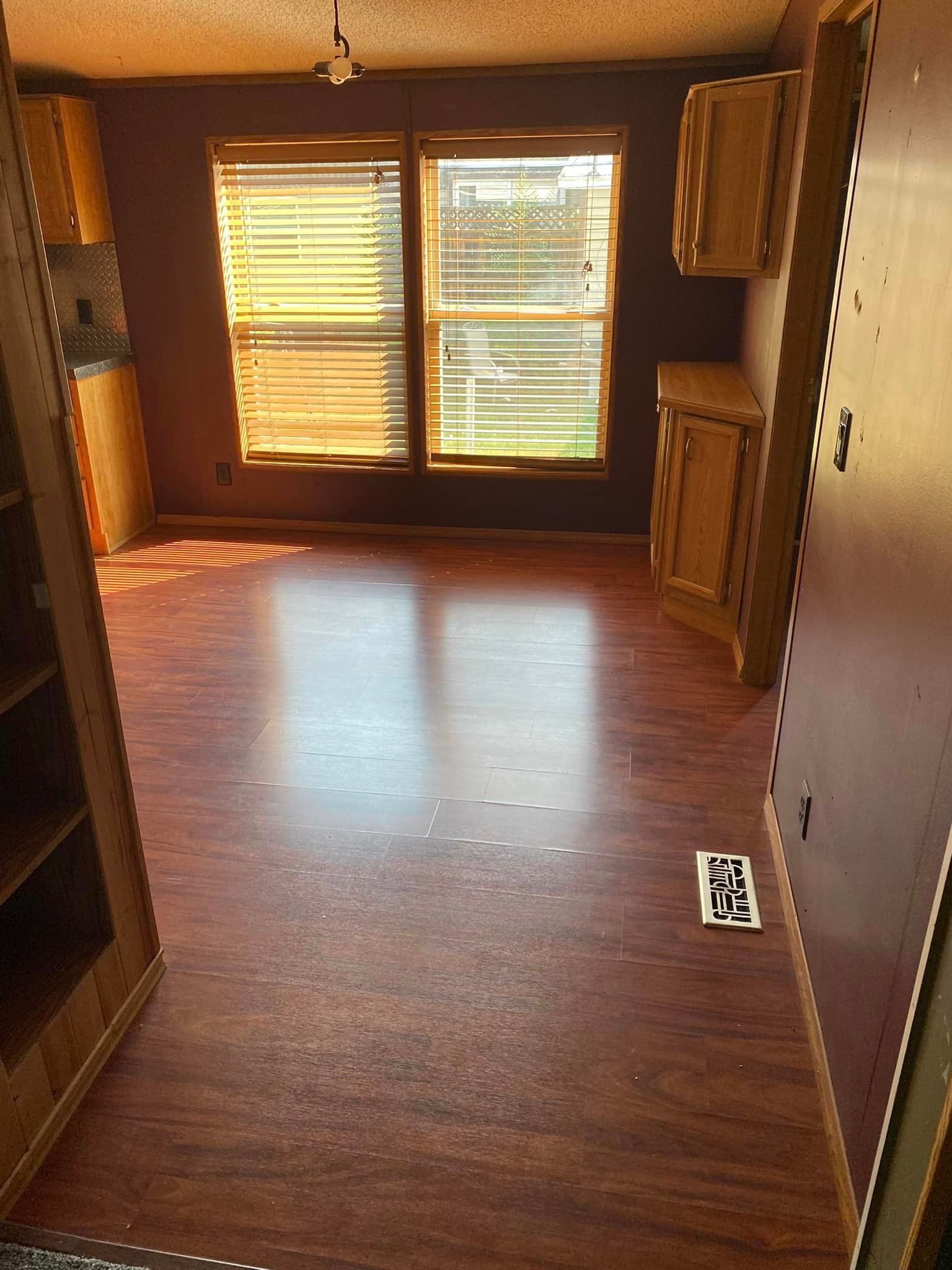 An empty room with hardwood floors and a window.