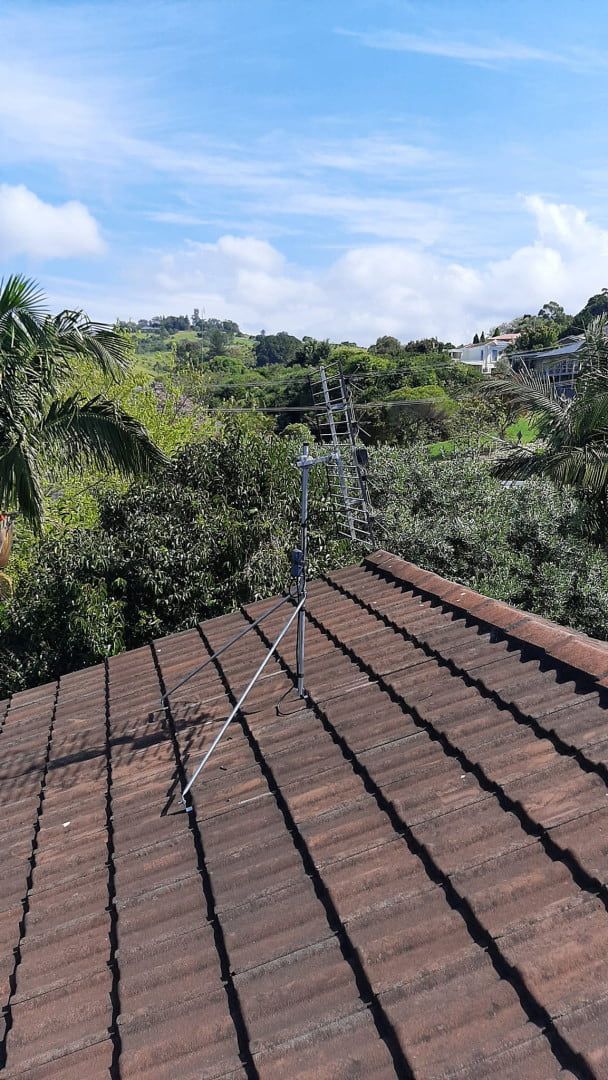 A Roof With A Satellite Dish On It And Trees — Boardman's TV Antennas in Basin View, NSW