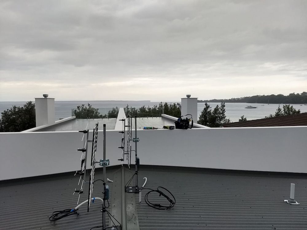 A Rooftop With Antennas On It And A View Of The Ocean — Boardman's TV Antennas in Basin View, NSW
