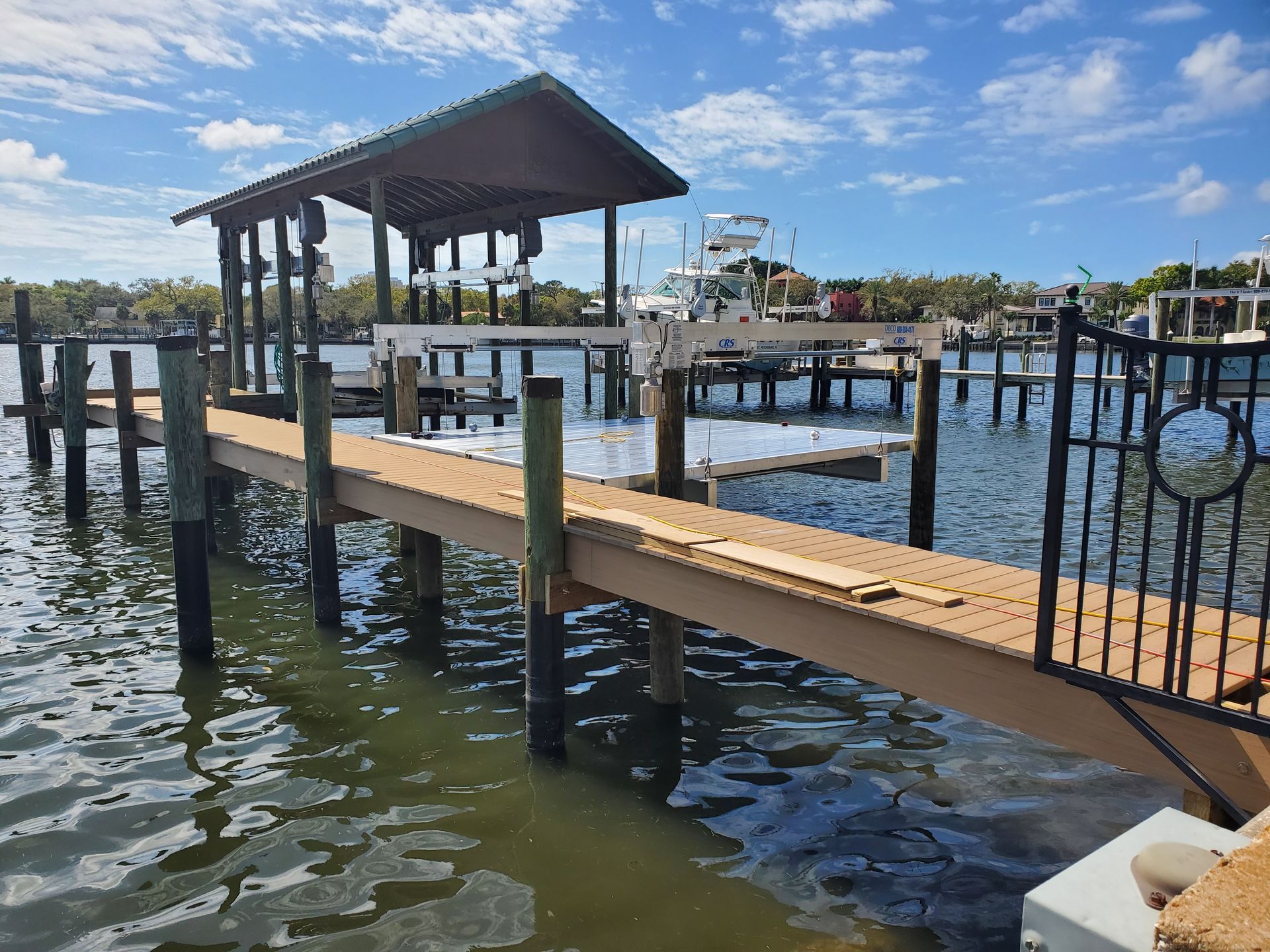 A dock in the middle of a body of water with a boat in the background.