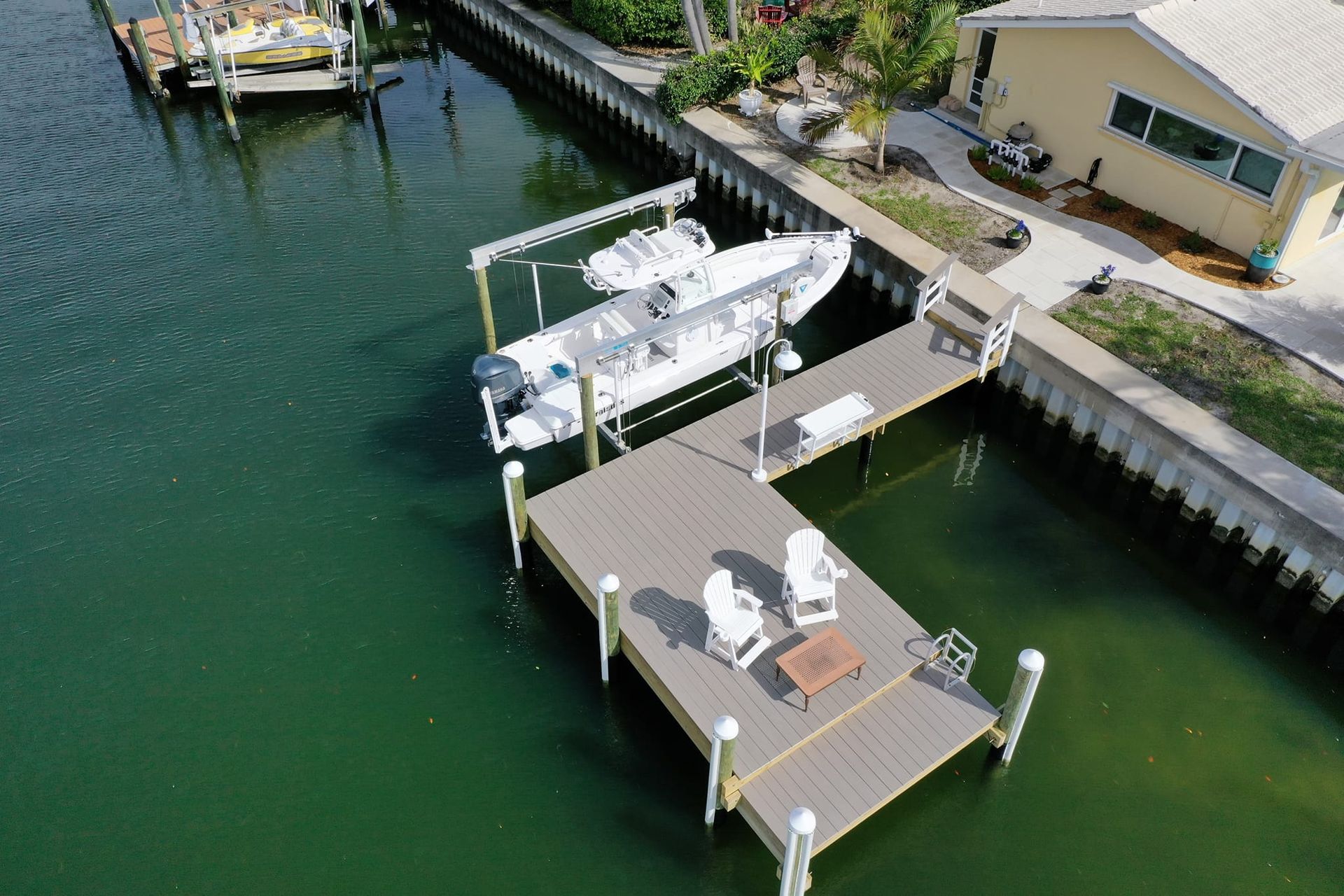 An aerial view of a dock with a boat on it at a residential home.