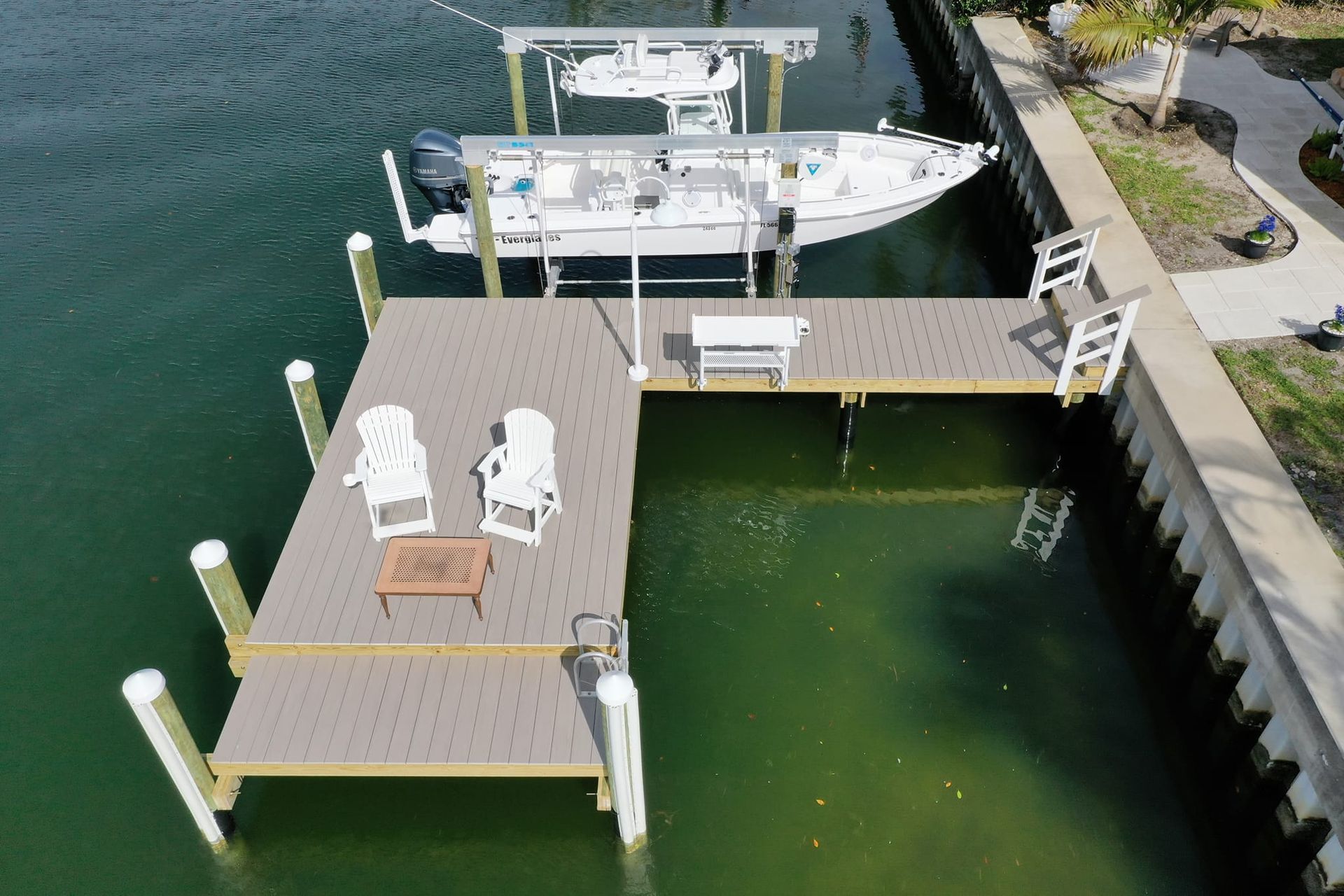 An aerial view of a dock with chairs and a boat
