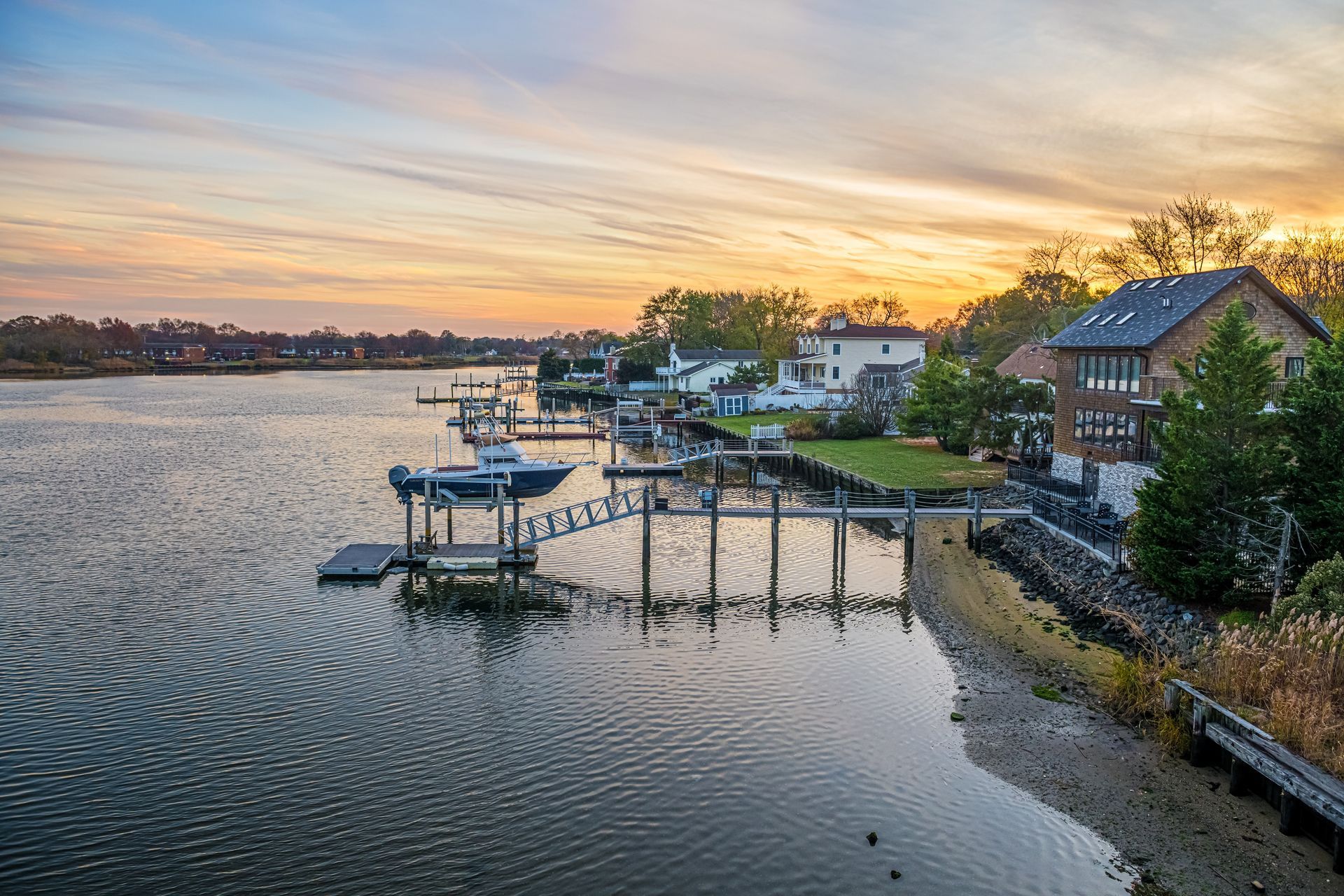 A sunset over a body of water with boats docked at a dock.