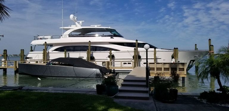 A large white yacht is docked at a dock.