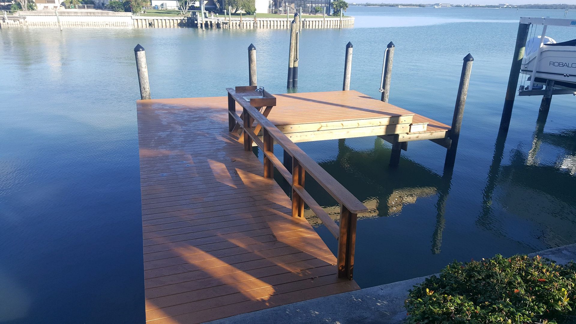 A wooden dock is sitting in the middle of a body of water.