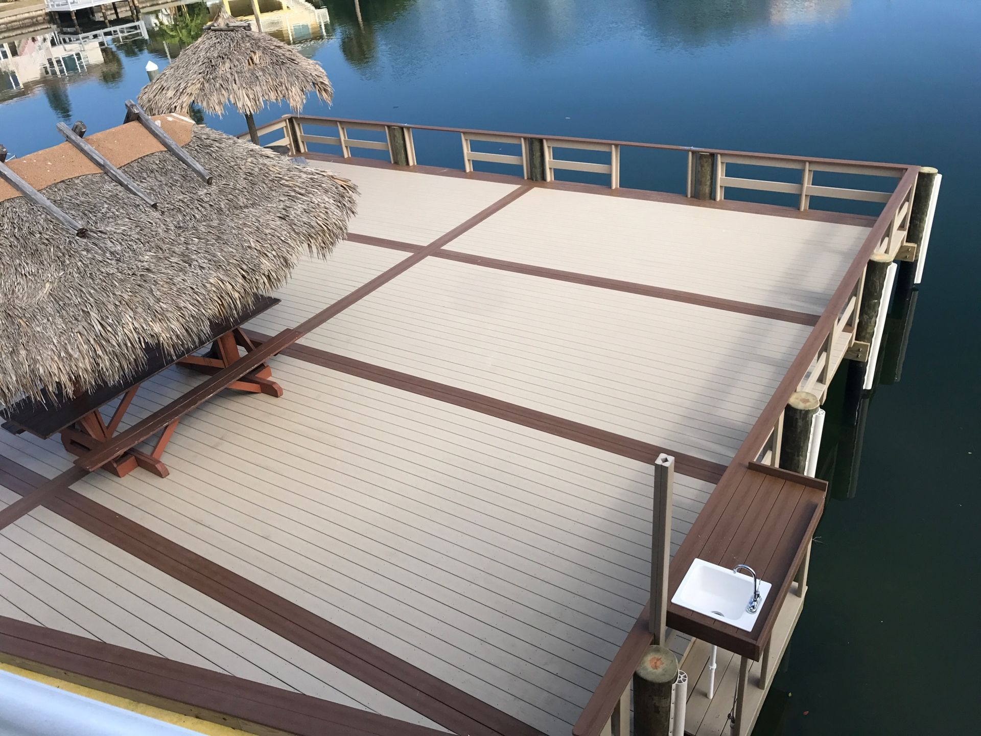A deck with a table and umbrellas on it overlooking a body of water.