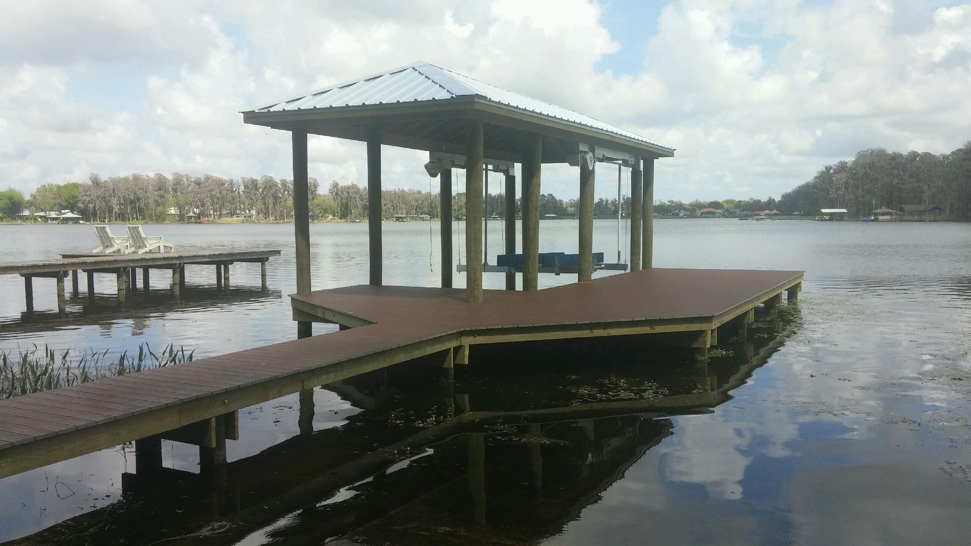 A dock in the middle of a lake with a bench on it.