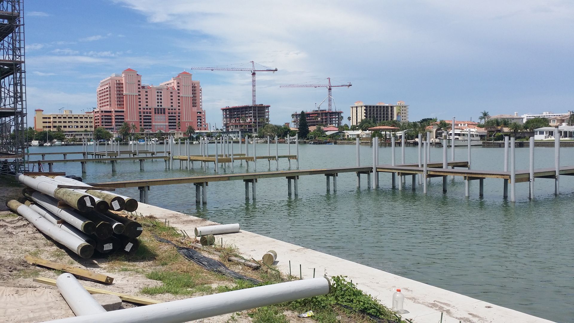 A large body of water with a dock in the foreground and a city in the background.