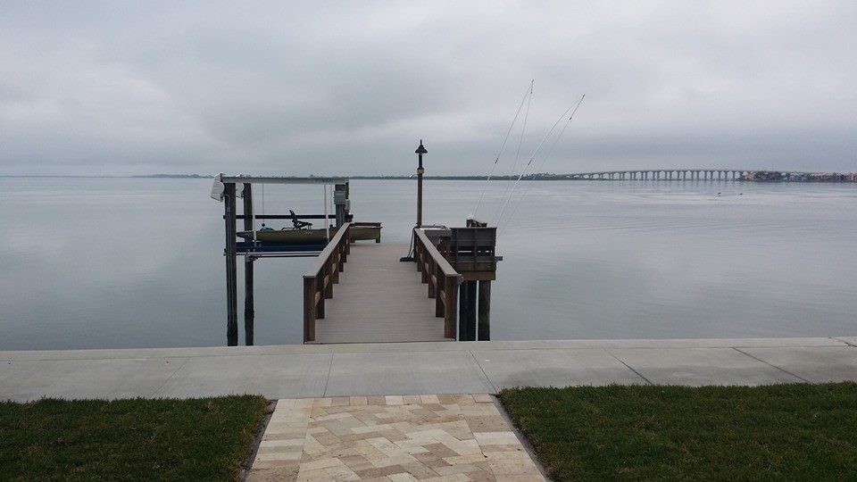 A dock in the middle of a body of water on a cloudy day.