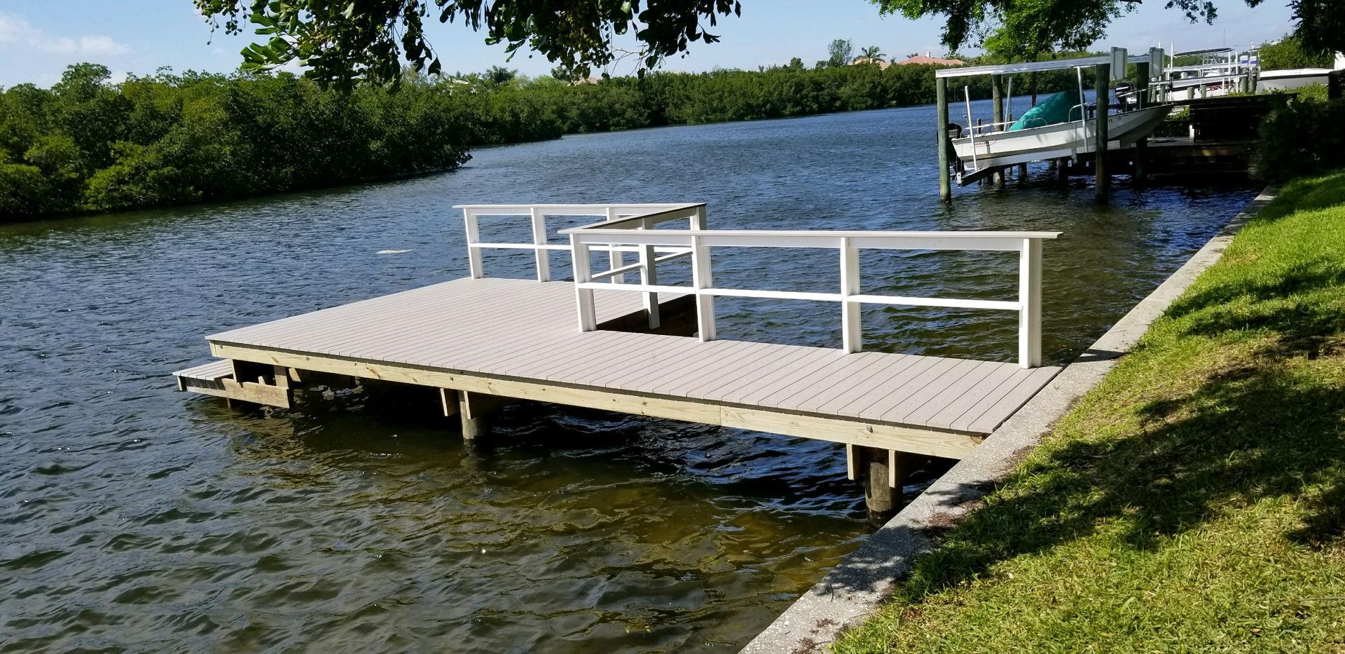 A dock docked in a body of water with a boat in the background.