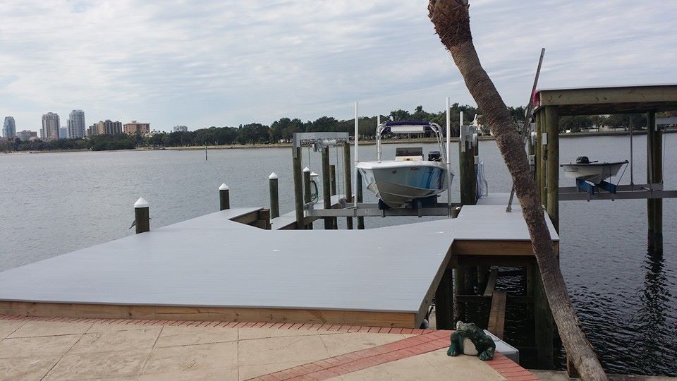 A boat is docked at a dock with a city in the background
