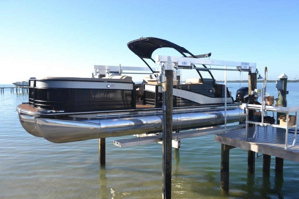 A pontoon boat is docked at a dock in the water.