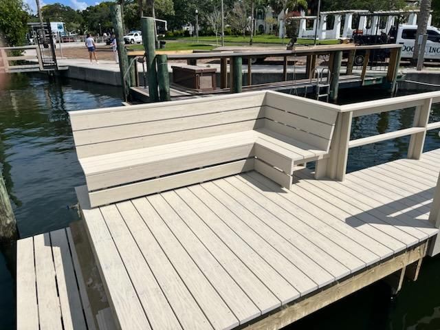 A wooden dock with a bench on it next to a body of water.