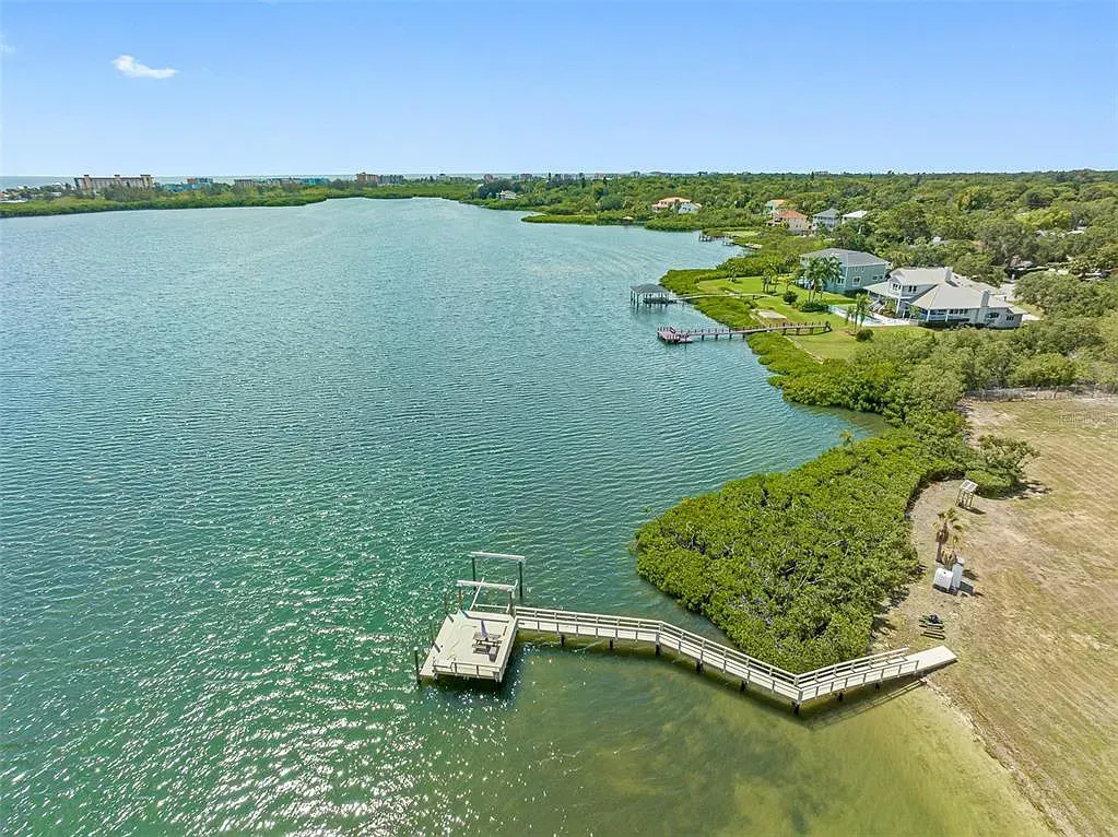 An aerial view of a large body of water with a dock in the middle of it.