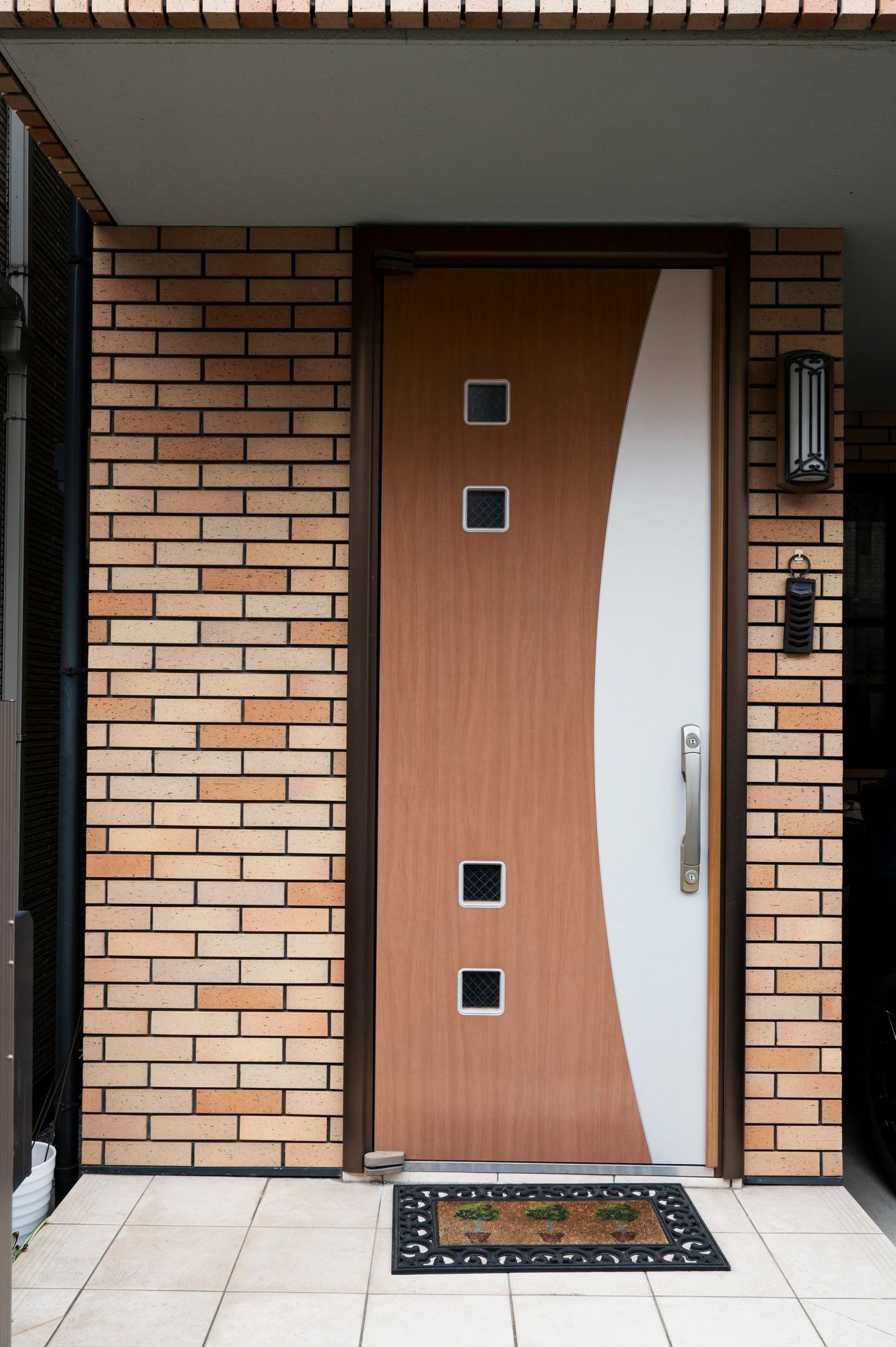 a brick building with a wooden door and a welcome mat