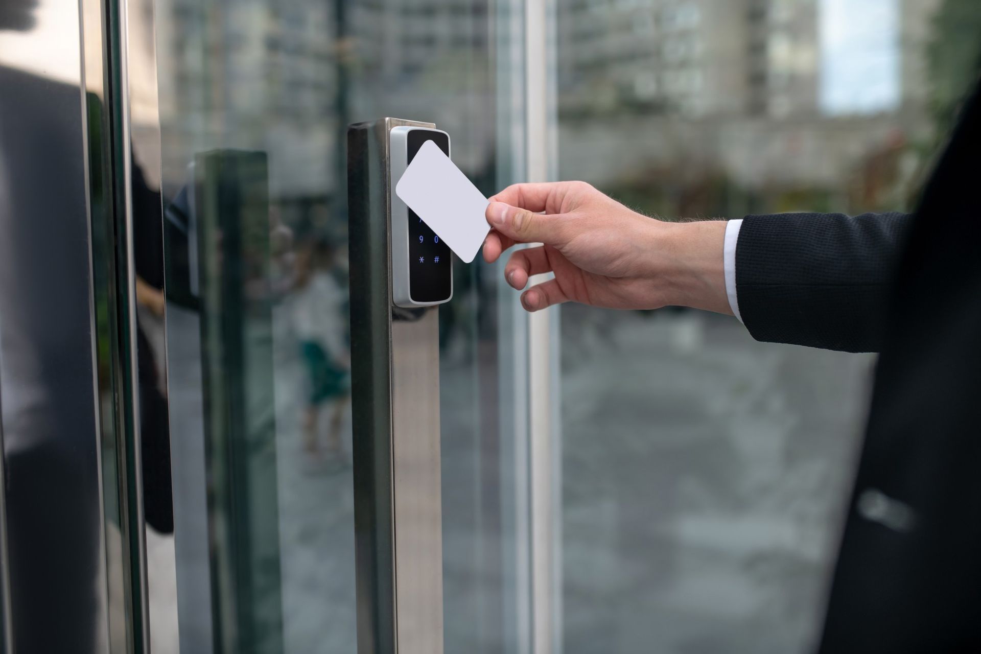 a man is using a smart card to open a glass door .