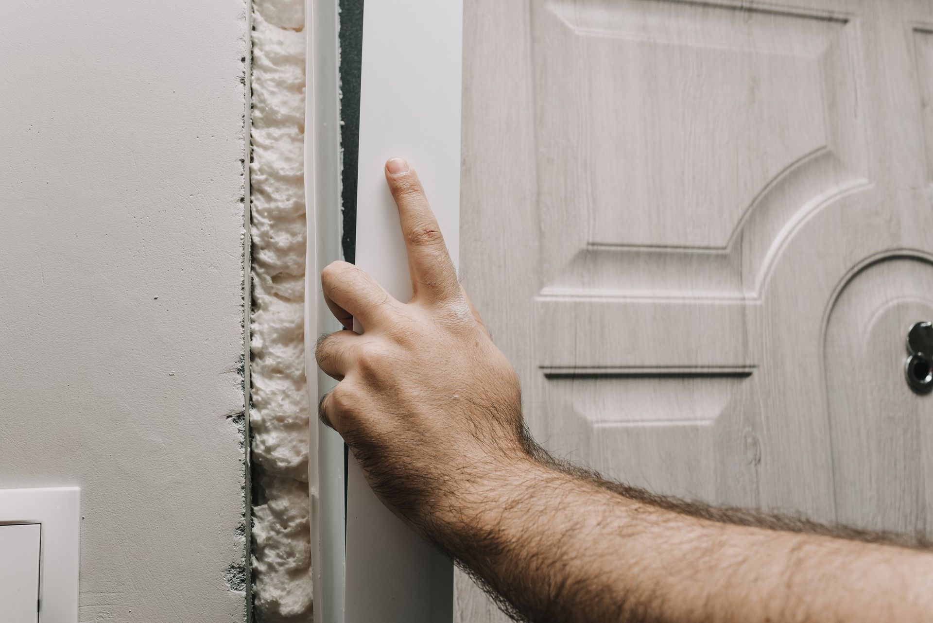 a man is applying foam to a door frame