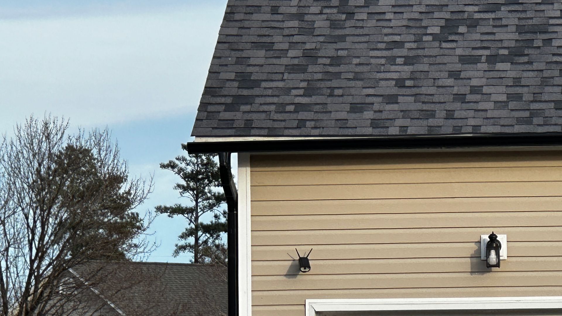 A house with a black roof and a light on the side