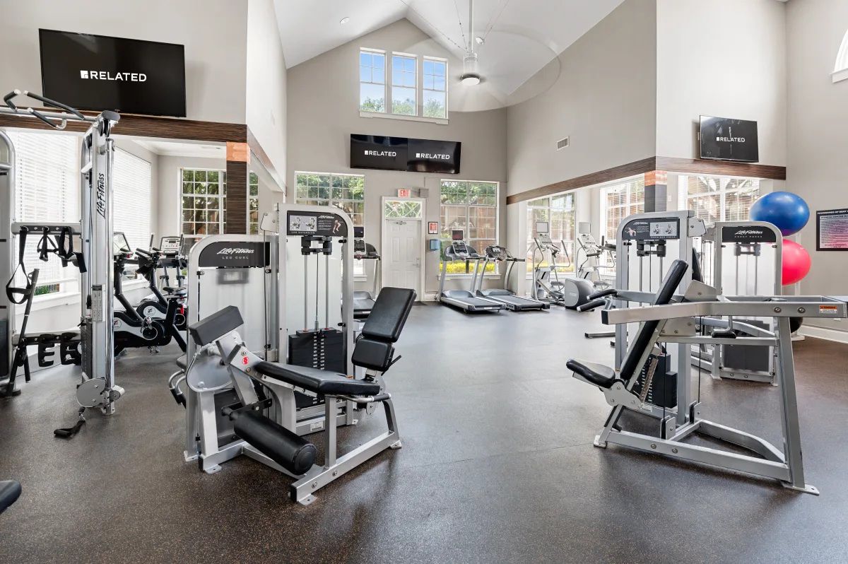 Gym with weight machines, treadmills, and large windows at Townhomes of Bent Tree, offers pet-friendly apartments in North Dallas, TX.