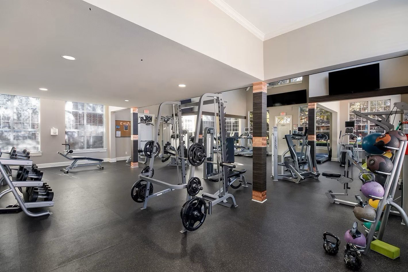 Gym interior with weight machines, free weights, and exercise equipment at Townhomes of Bent Tree, offers pet-friendly apartments in North Dallas, TX.