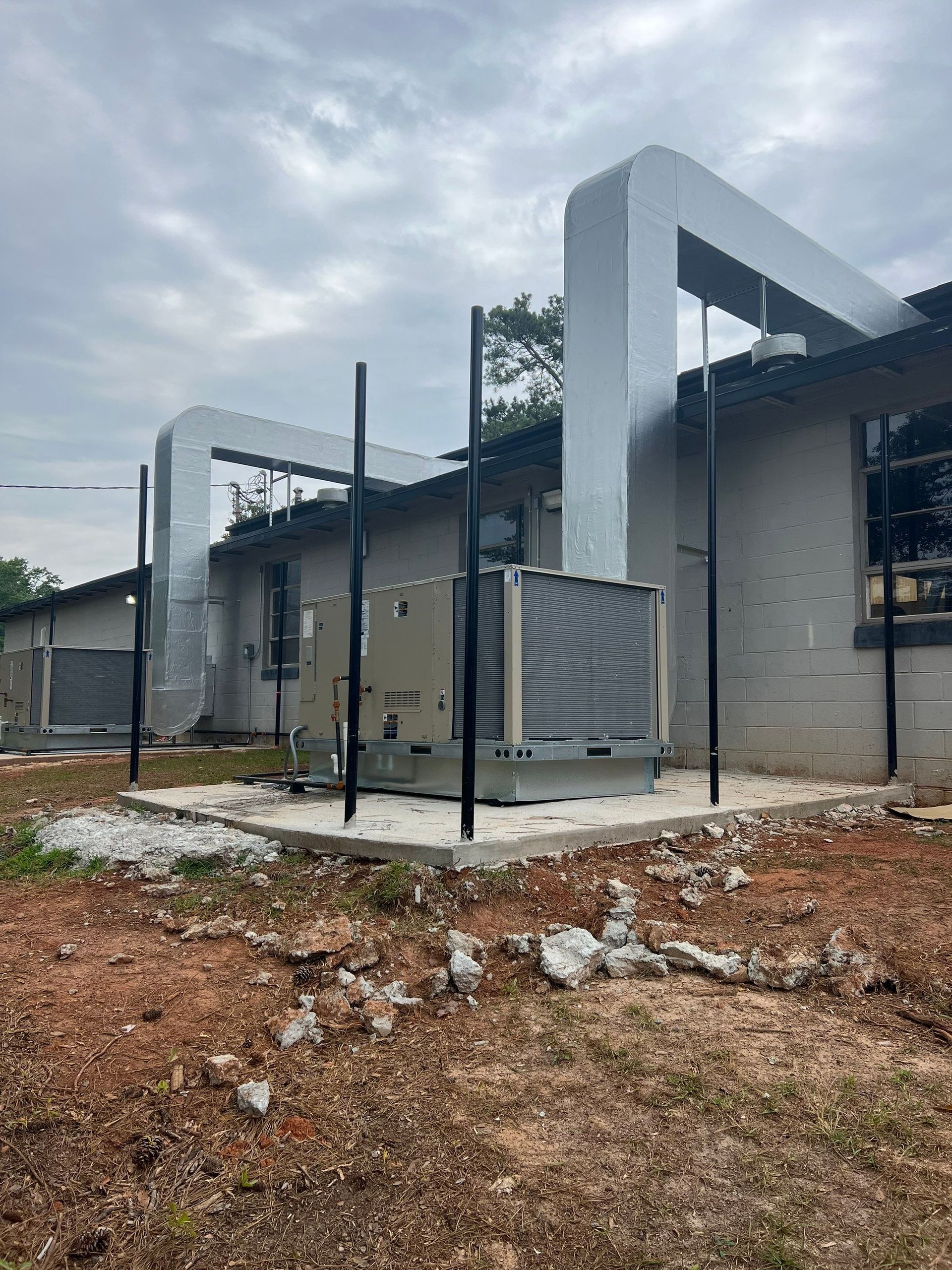 A building under construction with a lot of pipes coming out of it.