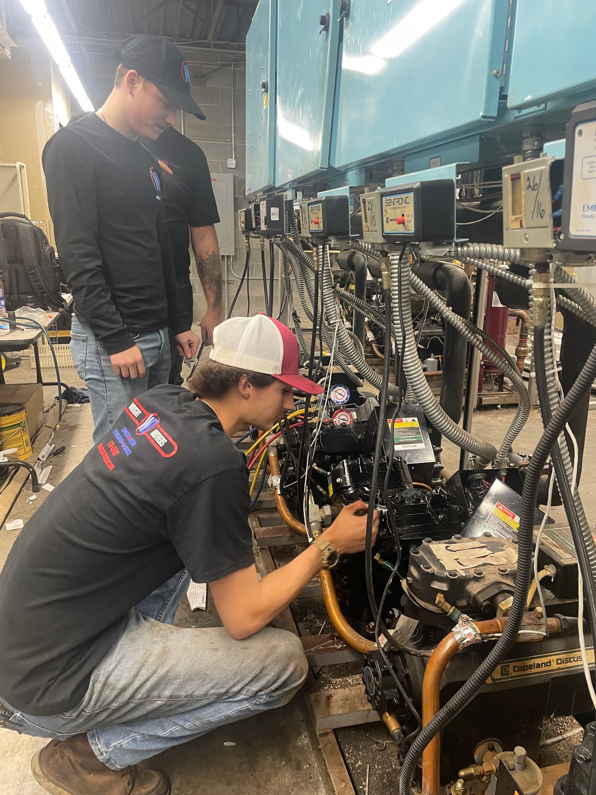 Two men are working on a machine in a factory.
