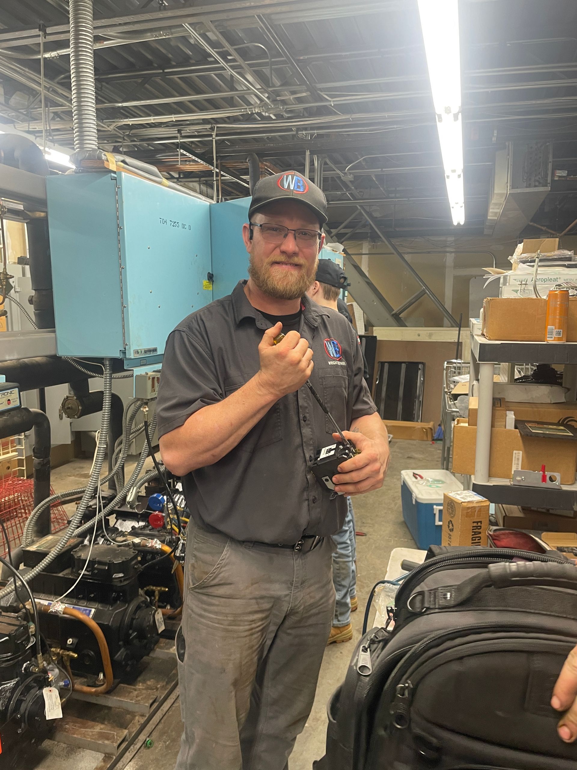 A man is standing in a warehouse holding a remote control