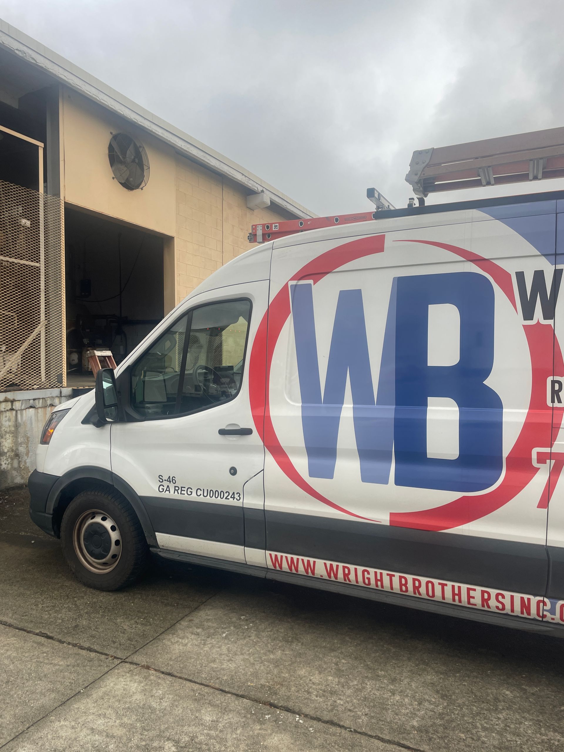 An air conditioner is sitting outside of a brick building.