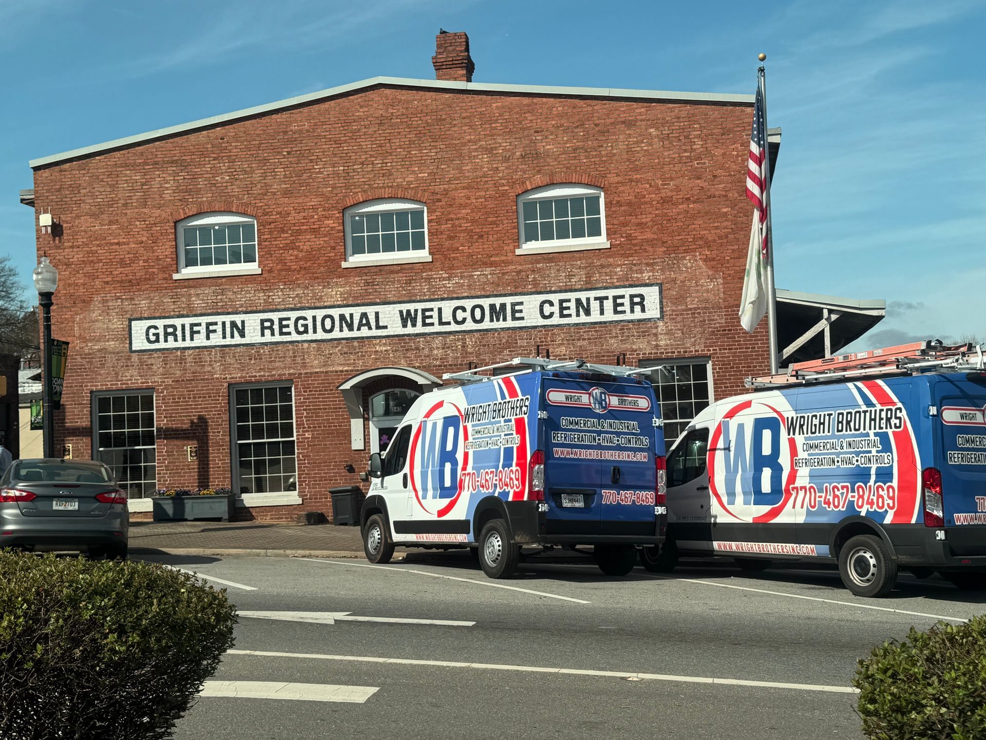 A row of air conditioners are lined up in front of a building.