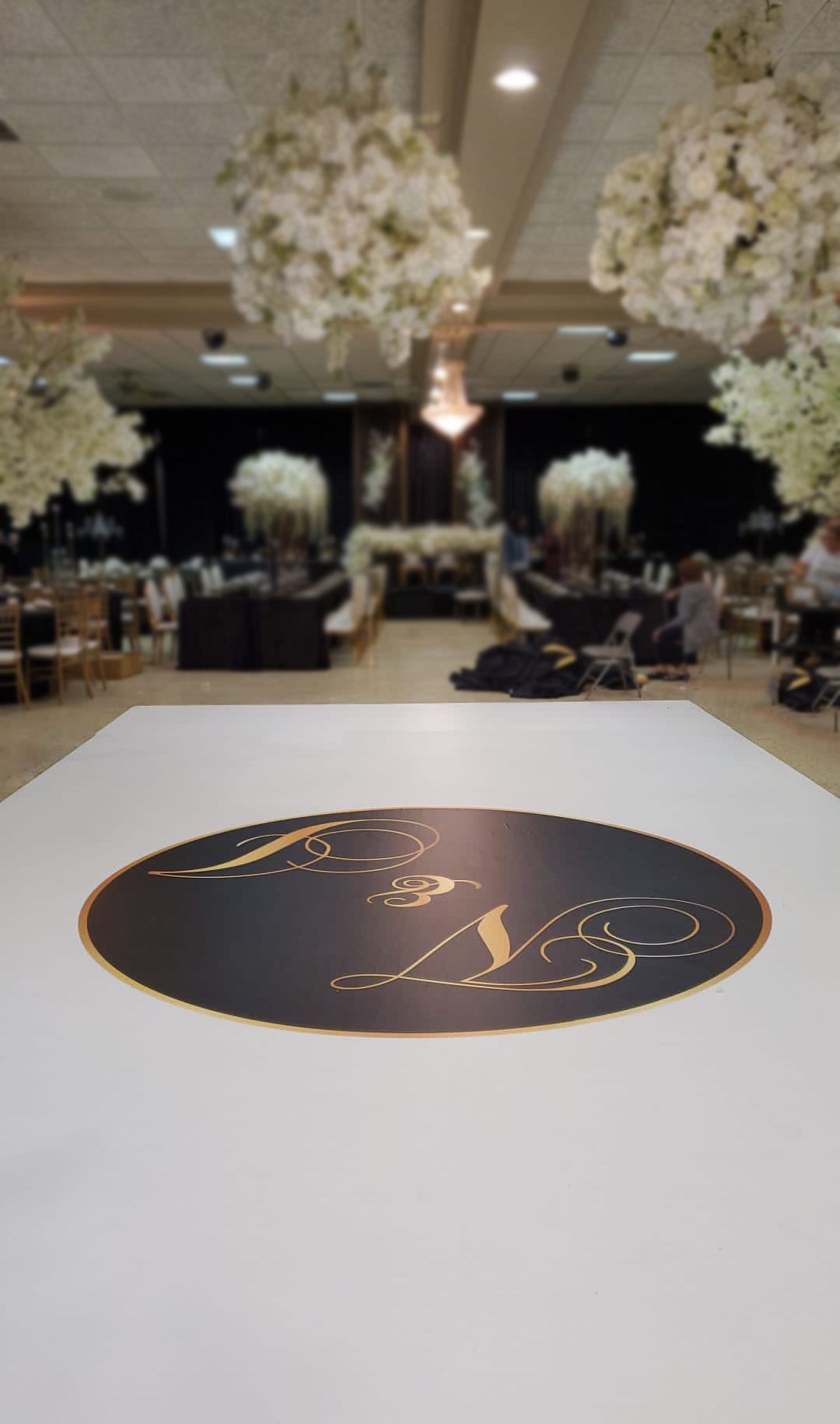 There is a dance floor with a logo on it in the middle of the room.