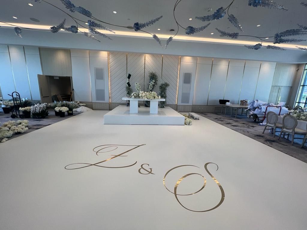 A large room with a dance floor and a table with flowers on it.