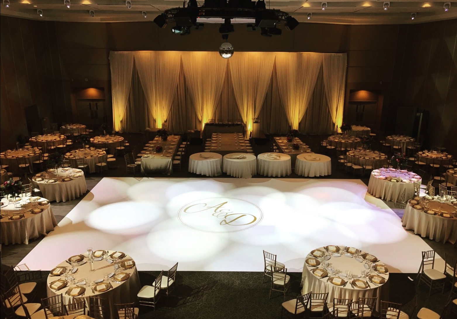 A large room with tables and chairs and a dance floor